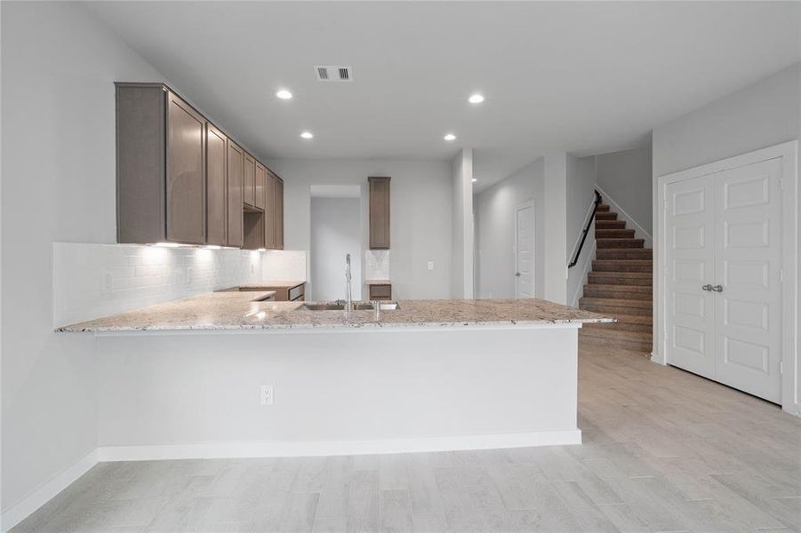 This kitchen is by far any chef’s dream! This spacious kitchen features high ceilings, stained wood cabinets, granite countertops, SS appliances, modern tile backsplash, recessed lighting, extended counter space for breakfast bar, and a walk-in pantry all overlooking your huge family room.