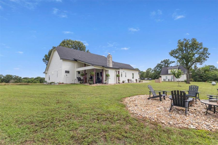 Beautiful custom farmhouse-style exterior set on expansive acreage, featuring inviting curb appeal, wide-open surroundings, mature trees, and a peaceful East Texas setting.