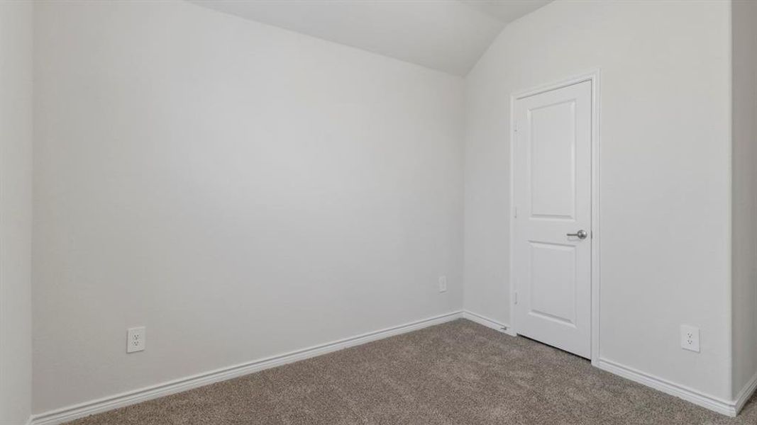 Carpeted spare room featuring baseboards and vaulted ceiling Carpeted spare room featuring baseboards and vaulted ceiling