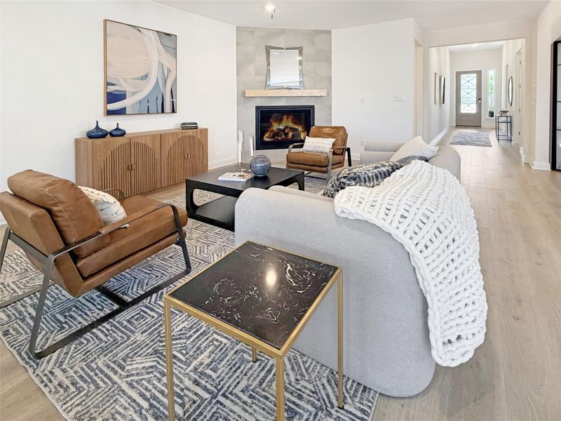 Living room with light wood-type flooring and a tiled fireplace