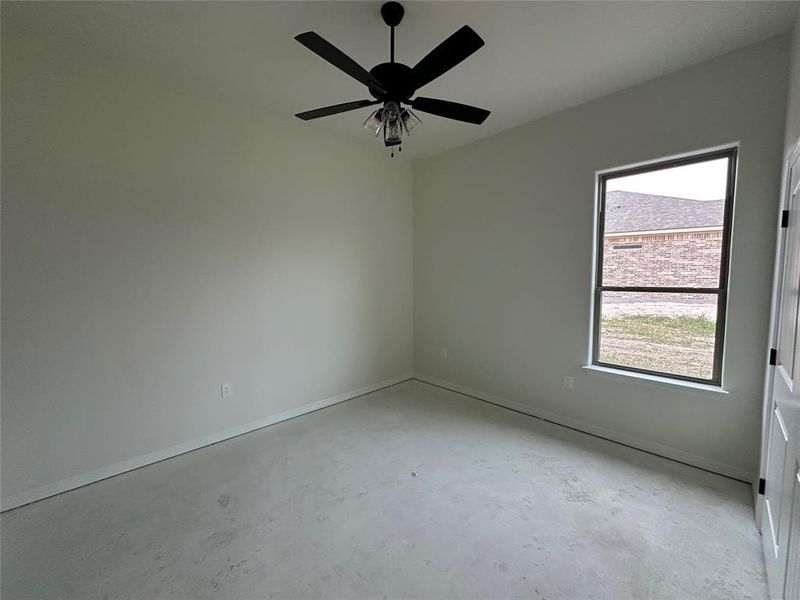 Unfurnished room featuring concrete floors and a ceiling fan
