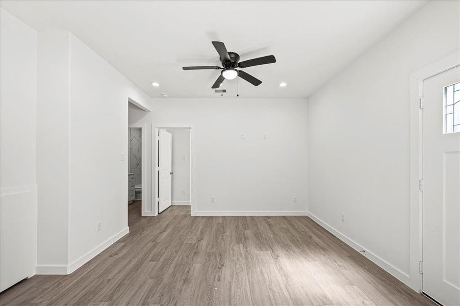 Spacious and open, featuring a ceiling fan and recessed lighting.