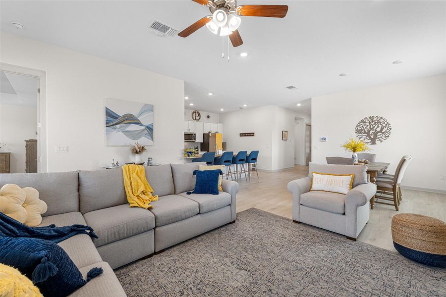 Living area with light wood-style floors, recessed lighting, and a ceiling fan Living area with light wood-style floors, recessed lighting, and a ceiling fan