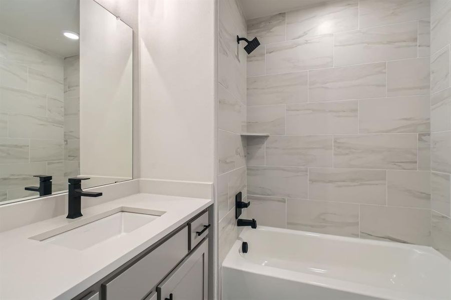 Full bathroom featuring vanity and bathing tub / shower combination Full bathroom featuring vanity and bathing tub / shower combination