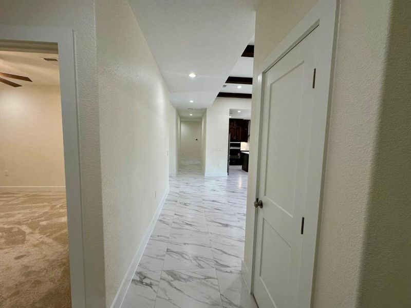 Hall with a textured wall and light marble finish floors