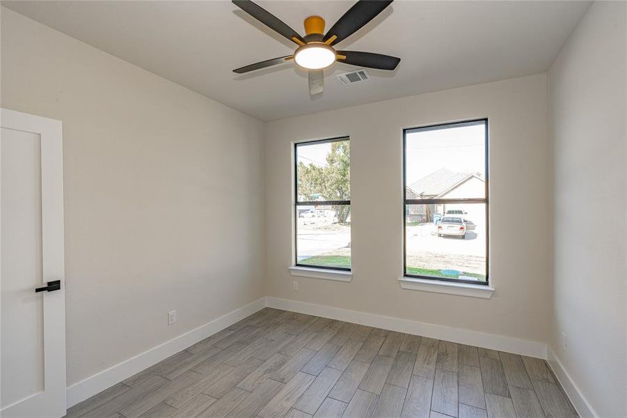 Empty room with ceiling fan and light hardwood / wood-style flooring