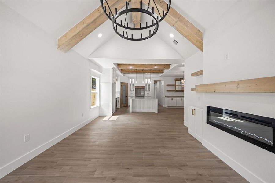 Vaulted ceiling with exposed wood beams and central chandelier