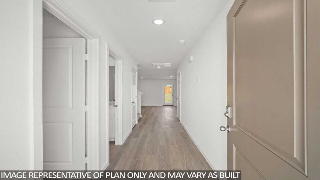 A welcoming entryway with sleek flooring guides the eye through an open floorplan toward the backyard.