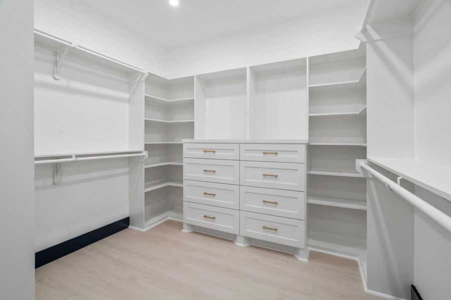 This well-designed Primary Bedroom walk-in closet offers ample storage with plenty of built-in shelving, drawers, and hanging rods. This well-designed Primary Bedroom walk-in closet offers ample storage with plenty of built-in shelving, drawers, and hanging rods.