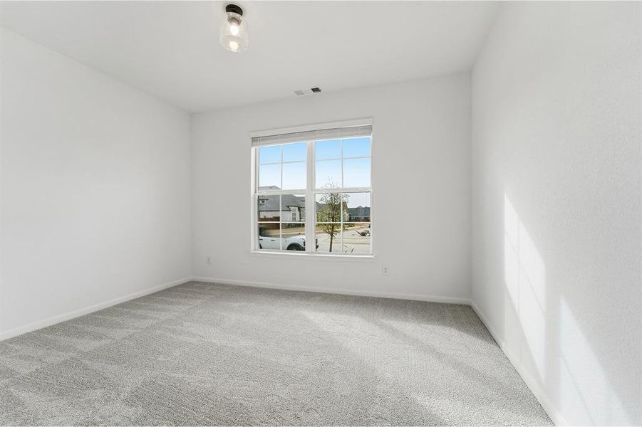 Bright room featuring a large window, neutral gray carpeting, white painted walls, and a contemporary ceiling light fixture