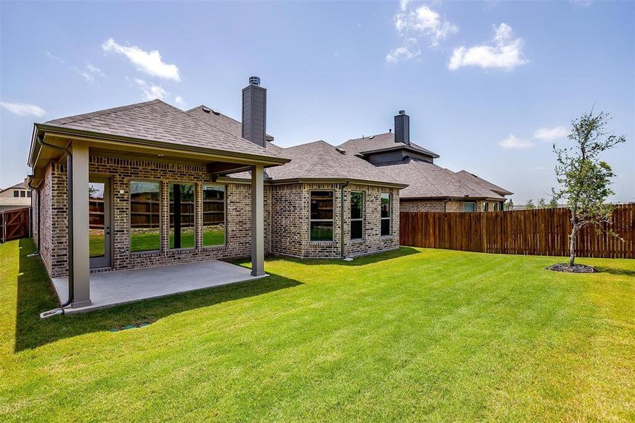 Back of property with a yard and a patio