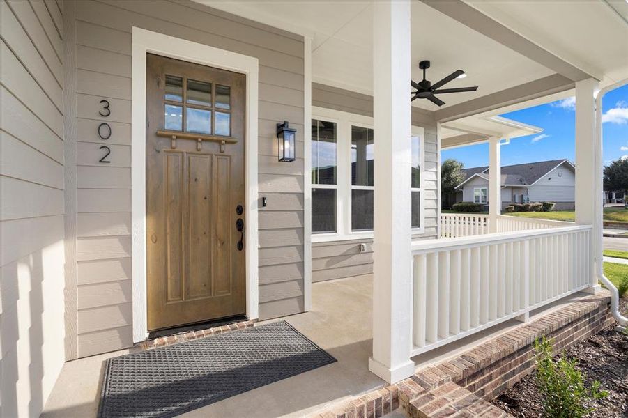 Entrance to property with ceiling fan and a porch