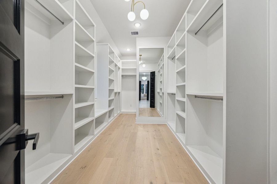 Large primary closet with abundant shelves, hanging racks, shoe storage, plus a full length mirror Large primary closet with abundant shelves, hanging racks, shoe storage, plus a full length mirror