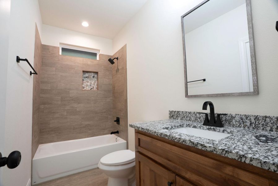 Bathroom with tub / shower combination, vanity, light wood finished floors, and recessed lighting Bathroom with tub / shower combination, vanity, light wood finished floors, and recessed lighting