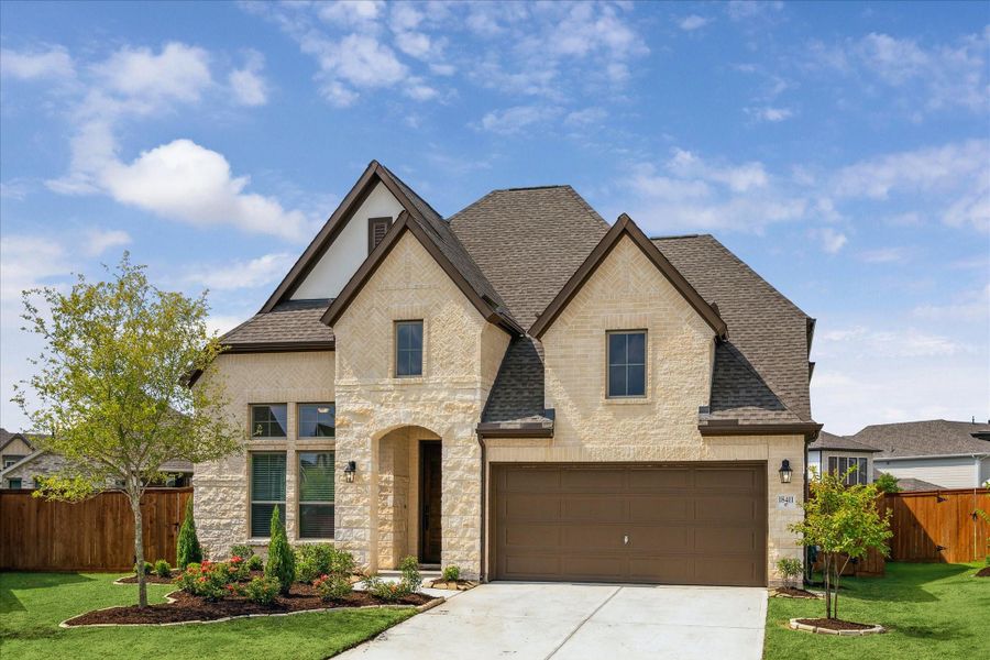 Welcome to 18411 Moonlit Arbor Trail! This 2024 home built by Coventry Builders showcases a striking brick-and-stone elevation, combining timeless charm with modern design.