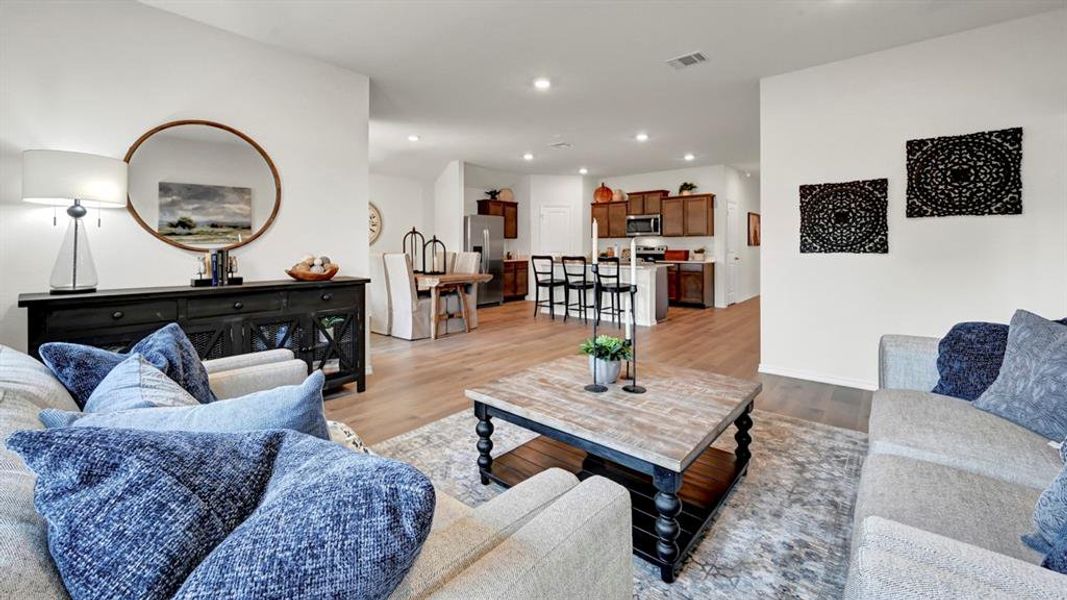 Living area with light wood-style flooring and recessed lighting
