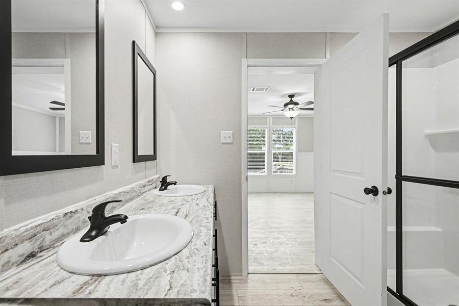 Primary bathroom vanity featuring dual oval sinks with matte black faucets, .