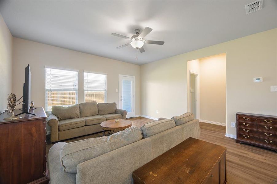 Bright living area featuring wood-finish flooring, neutral-toned walls, and a recessed doorway Bright living area featuring wood-finish flooring, neutral-toned walls, and a recessed doorway