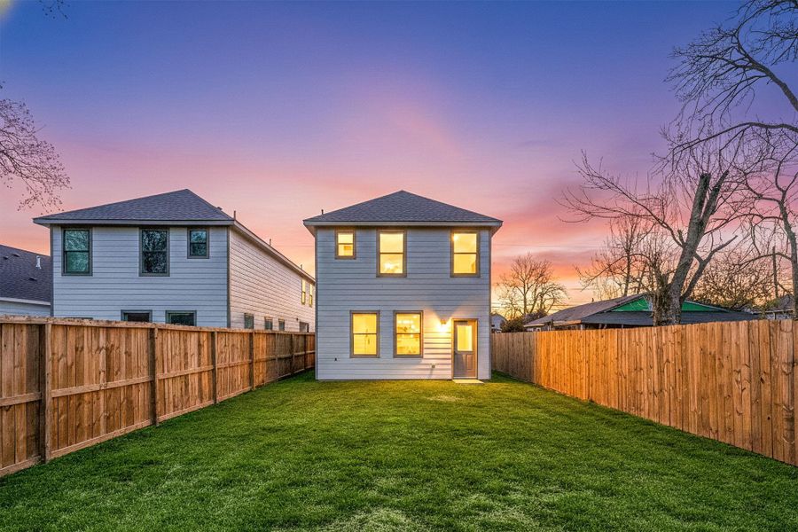 Private fenced backyard featuring a level grassy area, perfect for outdoor gatherings, pets, or play. Spacious yard with room to customize and enjoy outdoor living.