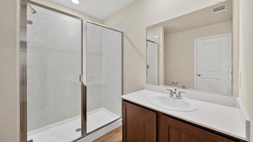 Contemporary bathroom featuring a walk-in shower with clear glass enclosure and light-toned wall panels