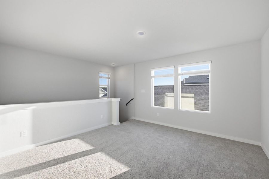A spacious, naturally illuminated loft provides an inviting secondary living area.