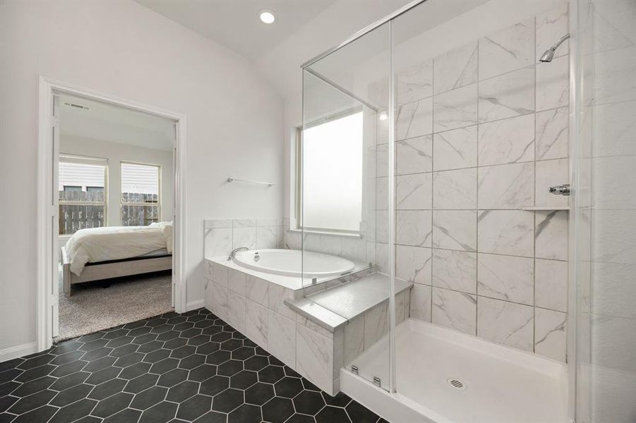 This additional view of the primary bath showcases the oversized walk-in shower with tile surround and a separate garden tub perfect for soaking after a long day.