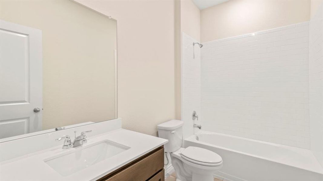 Bathroom featuring a vanity with an integrated sink, polished chrome faucet, and a large mirror