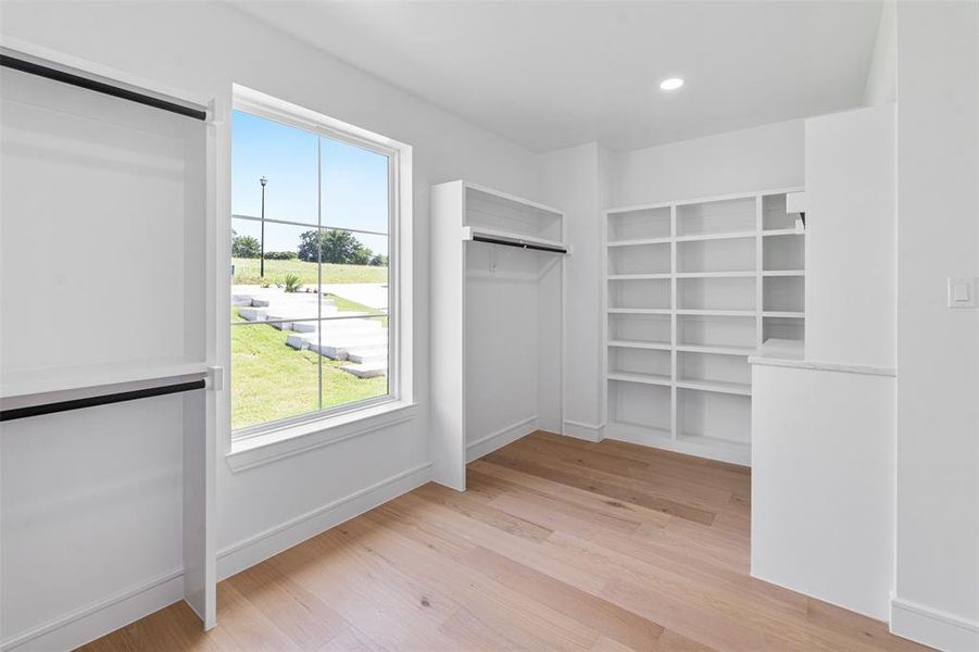 Primary closet with built many built in features Primary closet with built many built in features