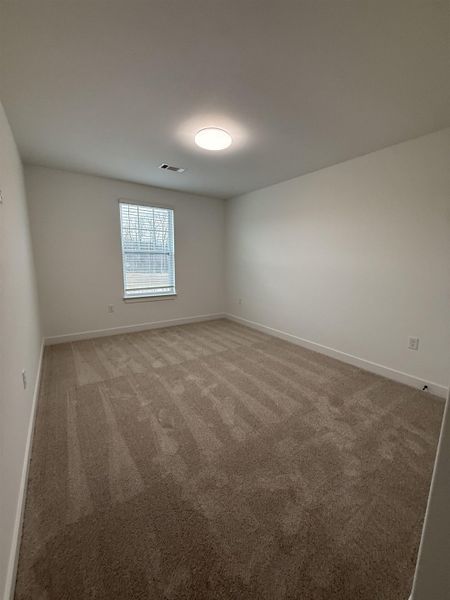 Spare room featuring light carpet and baseboards