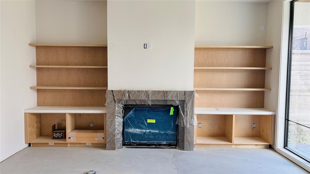 2/9/26: Elegant living room anchored by a silver stone fireplace and custom white oak cabinetry.