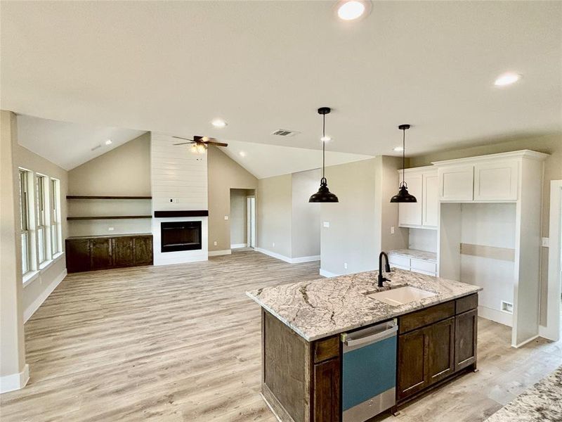 Kitchen featuring dishwashing machine, light wood-style floors, white cabinetry, light stone countertops, and ceiling fan Kitchen featuring dishwashing machine, light wood-style floors, white cabinetry, light stone countertops, and ceiling fan