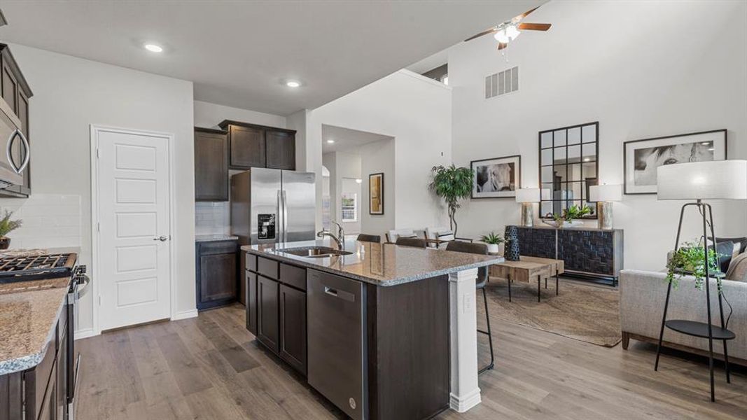Kitchen featuring dark wood cabinetry, granite countertops, and stainless steel appliances Kitchen featuring dark wood cabinetry, granite countertops, and stainless steel appliances