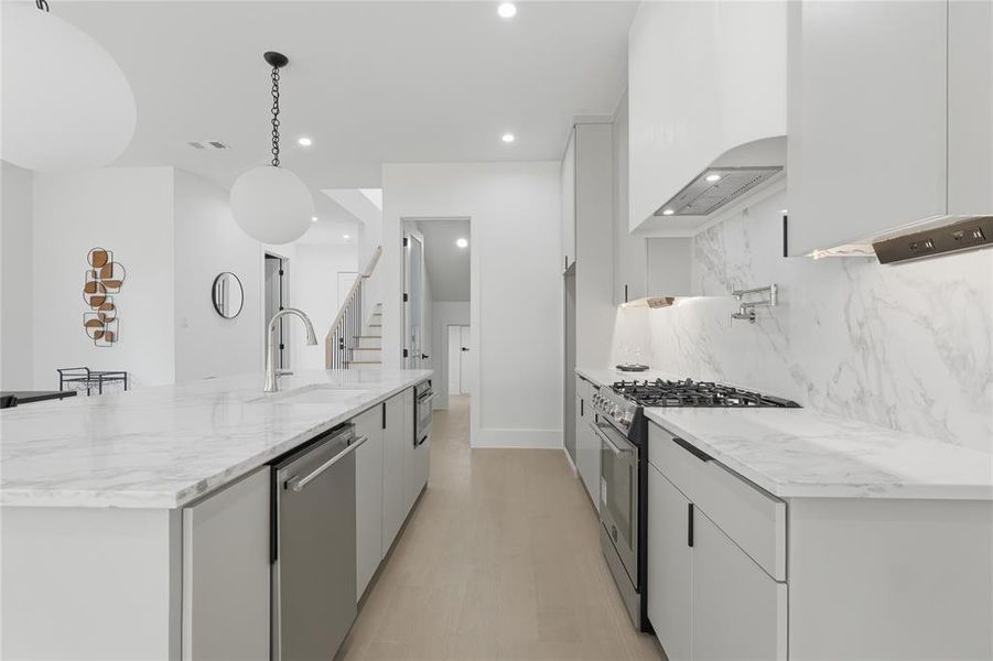 Modern kitchen featuring light wood-finish flooring and white walls