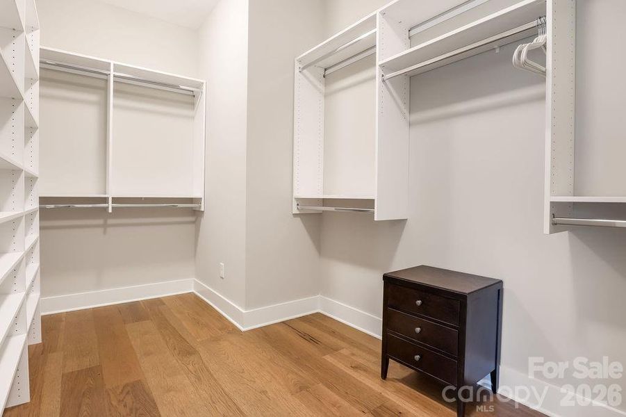 Spacious walk-in closet with built in shelving.