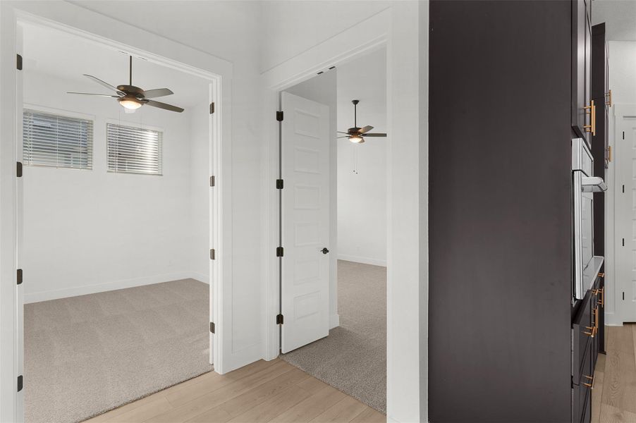 Hall featuring light wood finished floors and light colored carpet