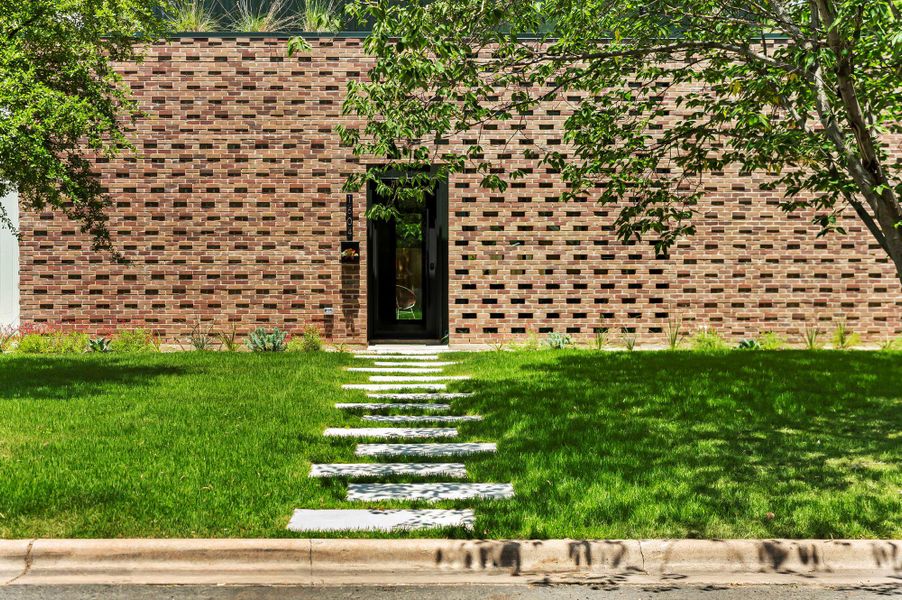 View of front of house with a front lawn and brick siding