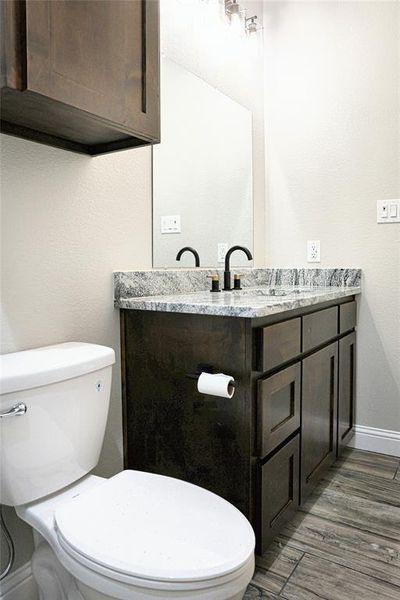 Secondary bathroom featuring vanity, tiled shower / bath, and toilet