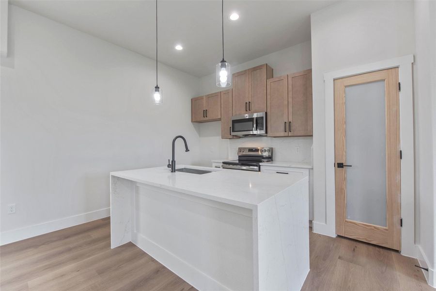 The kitchen features a large island with a farmhouse sink, beautiful cabinetry, a spacious pantry, and sleek stainless steel appliances. The kitchen features a large island with a farmhouse sink, beautiful cabinetry, a spacious pantry, and sleek stainless steel appliances.