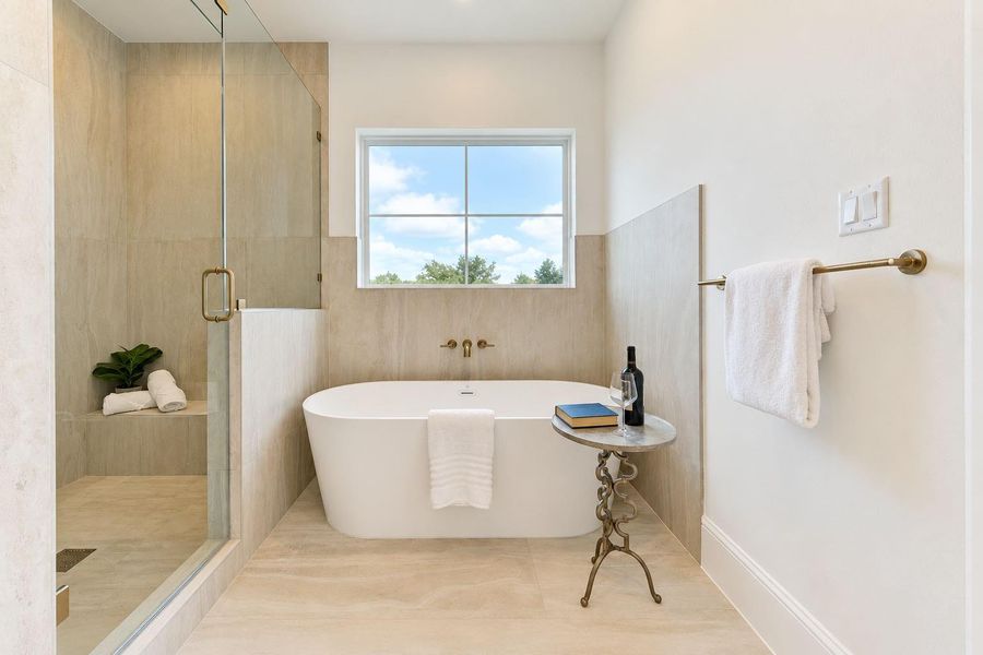A true spa-like escape, the primary bath showcases a sculptural freestanding soaking tub, oversized glass-enclosed shower, designer fixtures, and sophisticated tilework. Natural light and serene finishes create an indulgent atmosphere designed for unwinding in style. A true spa-like escape, the primary bath showcases a sculptural freestanding soaking tub, oversized glass-enclosed shower, designer fixtures, and sophisticated tilework. Natural light and serene finishes create an indulgent atmosphere designed for unwinding in style.