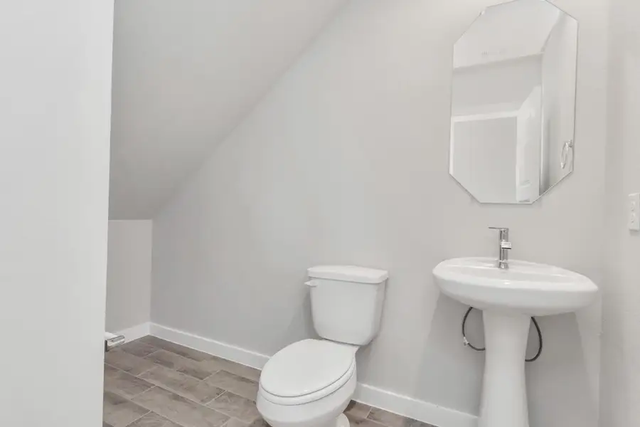 Step into this bright and airy half bath, where a sleek pedestal sink and modern hardware elevate the space with contemporary charm. Sample photo of completed home with similar floor plan. Actual colors and selections may vary. Step into this bright and airy half bath, where a sleek pedestal sink and modern hardware elevate the space with contemporary charm. Sample photo of completed home with similar floor plan. Actual colors and selections may vary.