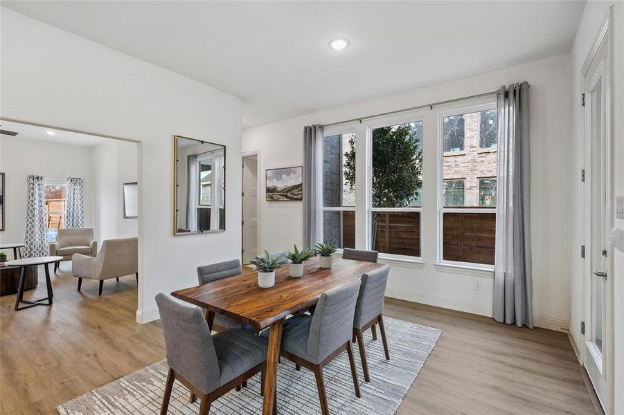 Dining area featuring wood-finish flooring, white walls, and recessed lighting