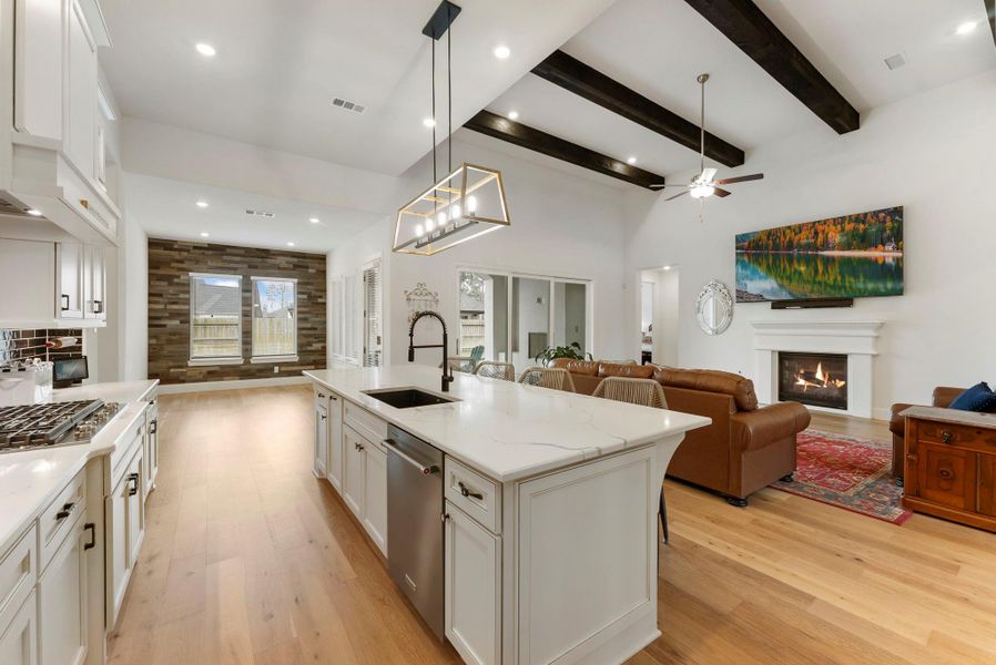 Designer lighting above the island complements the kitchen’s upscale finishes.