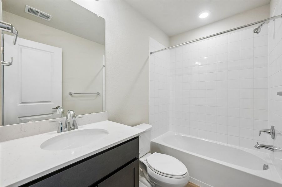 A bathroom with a tub sink and toilet.