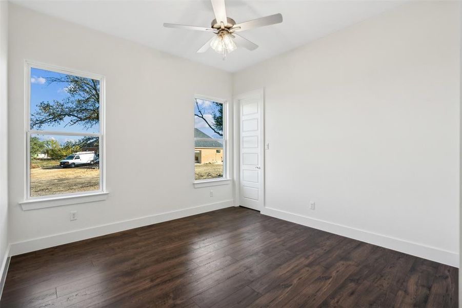 Spare room featuring ceiling fan and dark hardwood / wood-style flooring