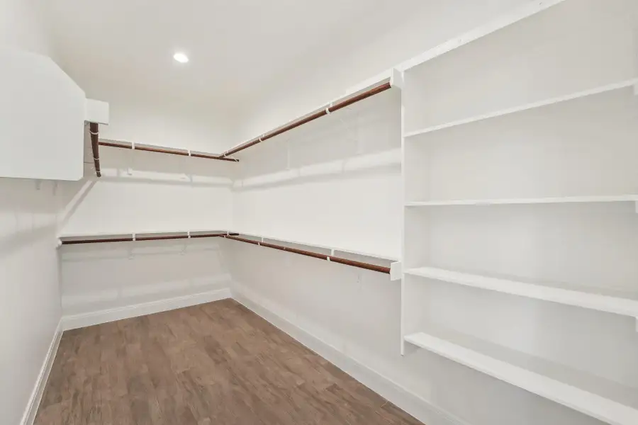 Primary Walk in closet featuring wood finished floors Primary Walk in closet featuring wood finished floors