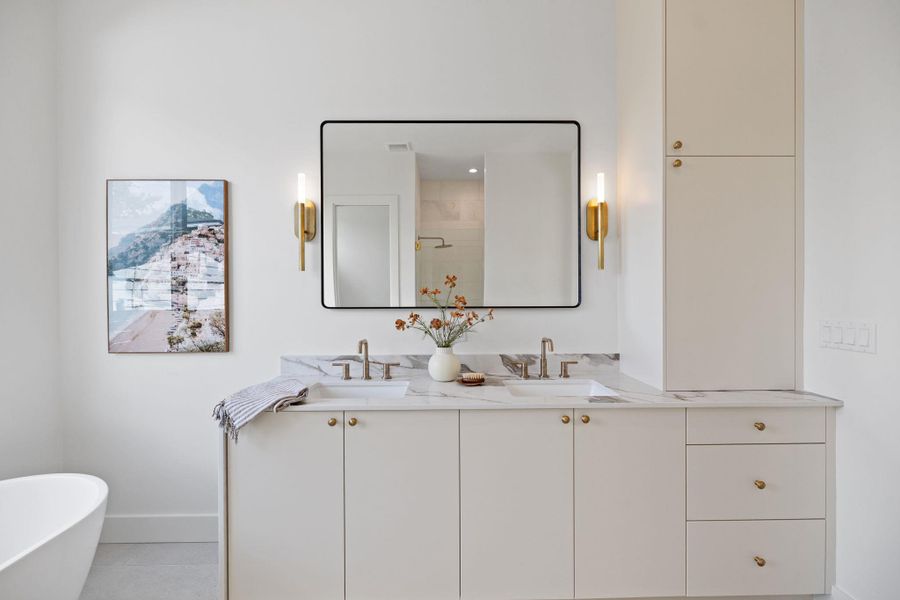 Full bathroom featuring a stall shower, double vanity, a freestanding tub, and light tile patterned floors Full bathroom featuring a stall shower, double vanity, a freestanding tub, and light tile patterned floors