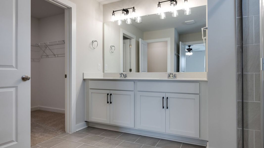 Walk-in closet next to dual sinks