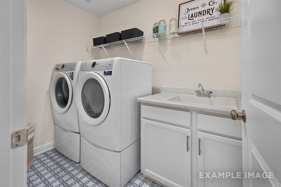 Laundry area with cabinets, sink, and washer and dryer