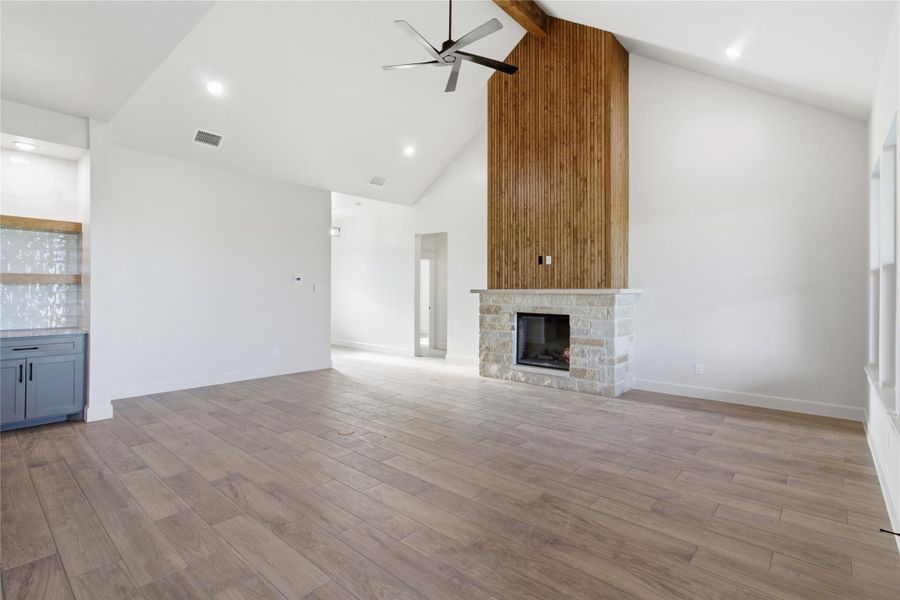 A striking stone fireplace with a soaring wood accent wall creates a compelling focal point in this spacious living area. A striking stone fireplace with a soaring wood accent wall creates a compelling focal point in this spacious living area.