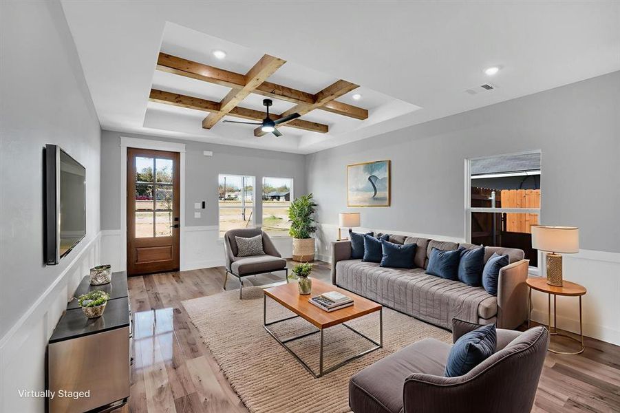 Family living area with light wood flooring, coffered ceiling with wood beam accents, ceiling fan, and recessed lighting.